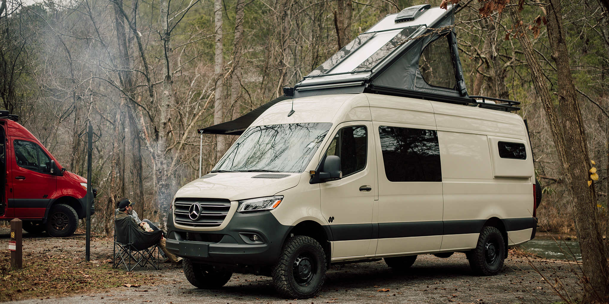 Pebble Gray Mercedes-Benz van with a Super pacific CloudCap on top parked in a wooded area.